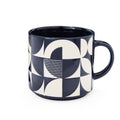 Stoneware mug with navy and white geometric pattern, glossy glaze and rounded handle.