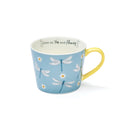 Sky-blue mug with dragonfly and daisy illustrations, yellow handle and interior, and ‘Live on tea and flowers’ message inside.