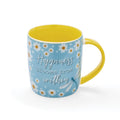 Soft blue barrel mug with daisy pattern, yellow handle and interior, and ‘Happiness blooms from within’ slogan.