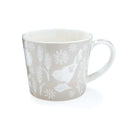 Soft neutral beige mug with tonal bird silhouette, floral and botanical motifs, and tapered shape.